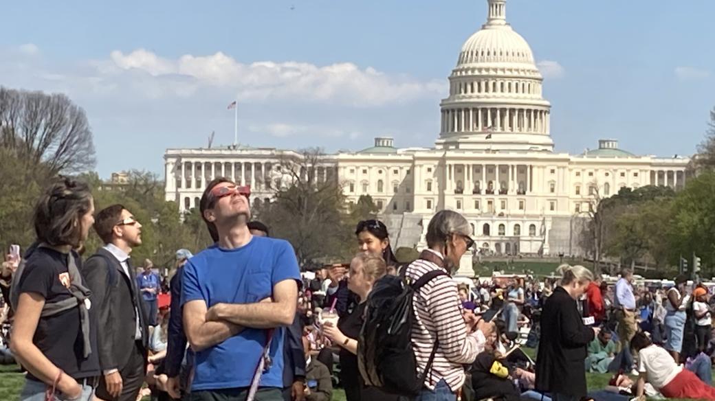 Obyvatelé Washingtonu pozorují částečné zatmění Slunce v parku National Mall